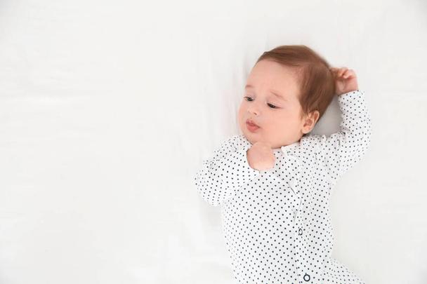Adorable baby on white sheet, top view. Space for text - Photo, Image