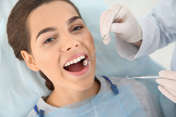 Dentist examining patient's teeth in modern clinic - Foto, afbeelding