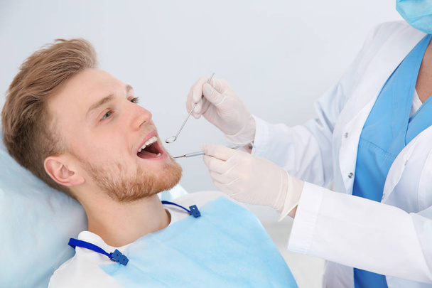 Dentist examining patient's teeth in modern clinic - Фото, зображення