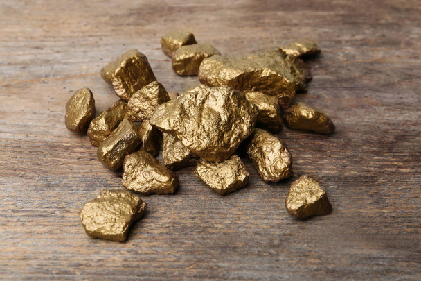 Pile of gold nuggets on wooden background - Fotografie, Obrázek