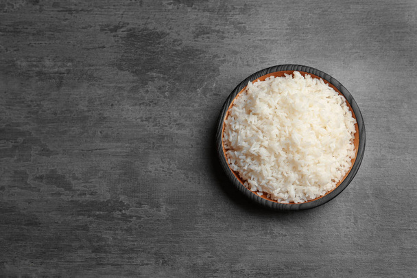 Boiled rice in bowl on grey background, top view with space for text - Zdjęcie, obraz