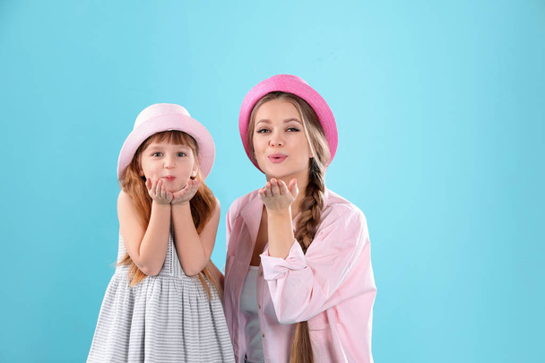 Happy woman and daughter in stylish clothes on color background - Fotoğraf, Görsel