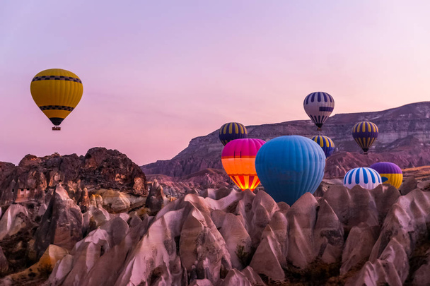Hot air balloon flying over spectacular Cappadocia, Tourists enjoy the overwhelming views over Cappadocia, Turkey. - Fotoğraf, Görsel