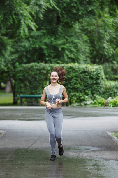 Jeune femme jogging sur le chemin dans le parc vert
 - Photo, image