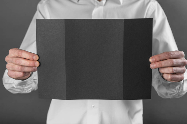A man holding black booklet - Fotó, kép