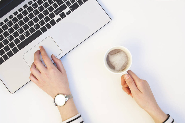 Vrouw handen laptop met koffiekopje op witte achtergrond. - Foto, afbeelding