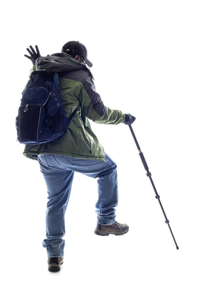 Mountain Climber or Hiker poking something with a stick.  The man is isolated and acting like he is looking at something in his path - Photo, image