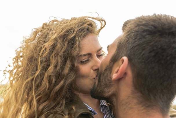 Attraktive und moderne Liebende küssen sich in der Natur - Foto, Bild