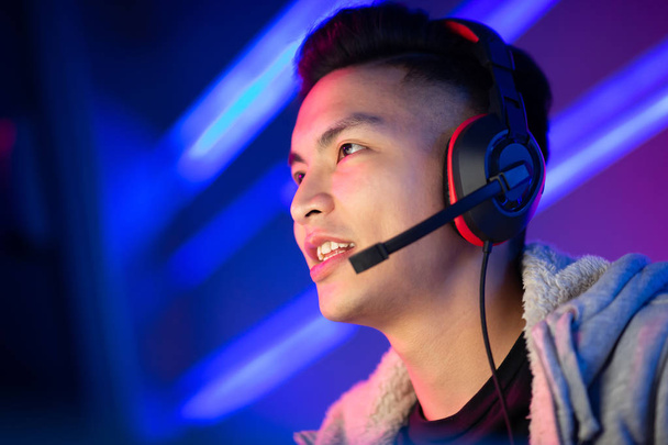 Young Asian Handsome Pro Gamer having live stream and playing in Online Video Game - Photo, image