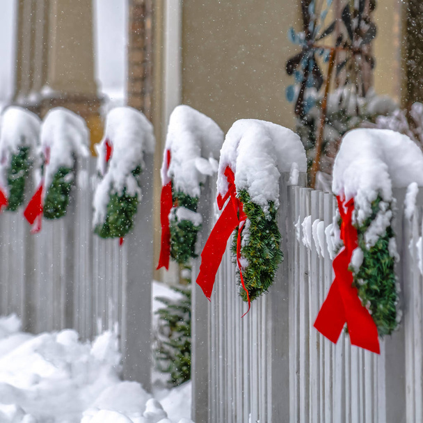 Coronas de Navidad en valla de madera blanca en invierno
 - Foto, Imagen