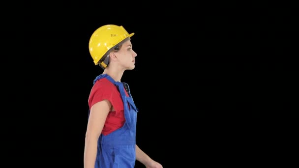 Young woman in yellow hardhat walking, Alpha Channel - Πλάνα, βίντεο