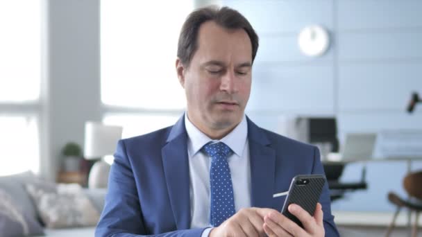 Middle Aged Businessman in Shock while Using Smartphone - Materiał filmowy, wideo