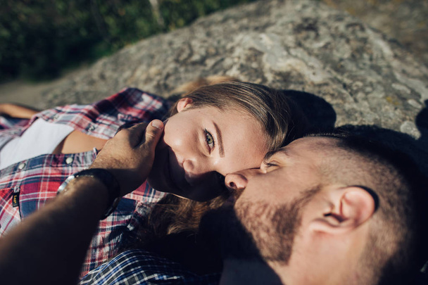 portrait of young hipster couple lying on mountain rock  - Foto, Bild