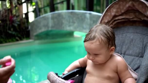 Děti a jídlo, matka dává dětská výživa dětská lžíce nedaleko plavecký bazén - Záběry, video