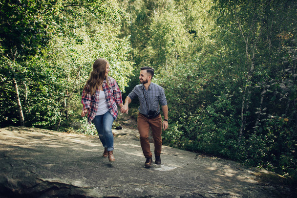 Young happy couple walking in green forest - Φωτογραφία, εικόνα