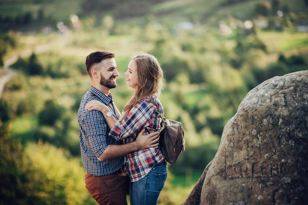 Young happy couple hugging in summer mountains  - Фото, изображение