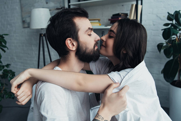 hermosa pareja joven romántica mirándose y abrazándose en casa
 - Foto, Imagen