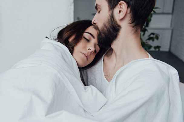 beautiful young couple sleeping in bed at home - Фото, изображение
