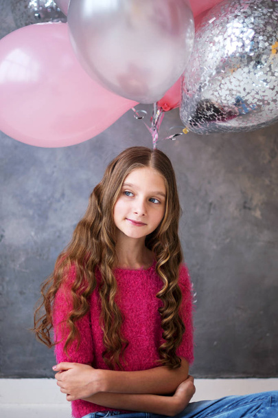 Girl with pink, grey balloons on grey background. Beautiful happy girl. Joyful model posing, celebrating Valentine's day. - Foto, Imagem