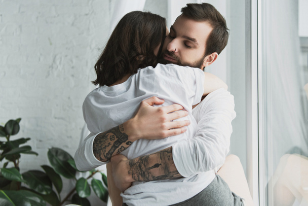 beautiful young couple passionately hugging at home - Zdjęcie, obraz