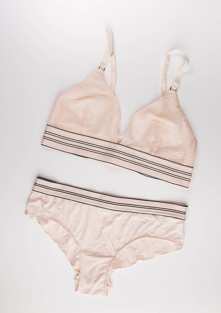 beige tender lingerie set isolated on a white background, top view - 写真・画像