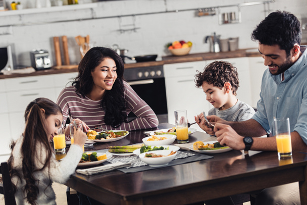 glückliche hispanische Familie lächelt beim Mittagessen zu Hause - Foto, Bild