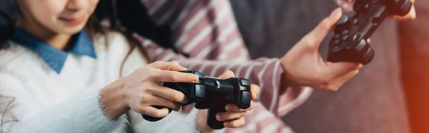 cropped view of kid playing video game with mother at home - Photo, Image