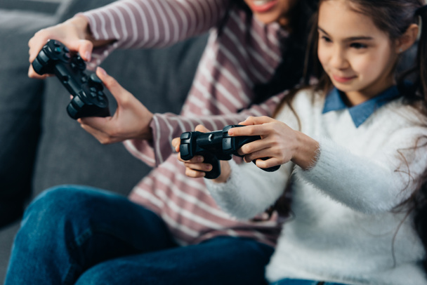 abgeschnittene Ansicht von niedlichen lateinischen Kind Videospiel mit Mutter zu Hause - Foto, Bild