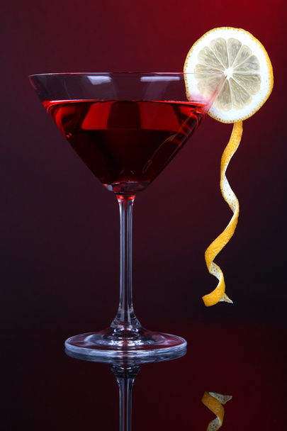 Red cocktail in martini glass on dark red background - Foto, imagen