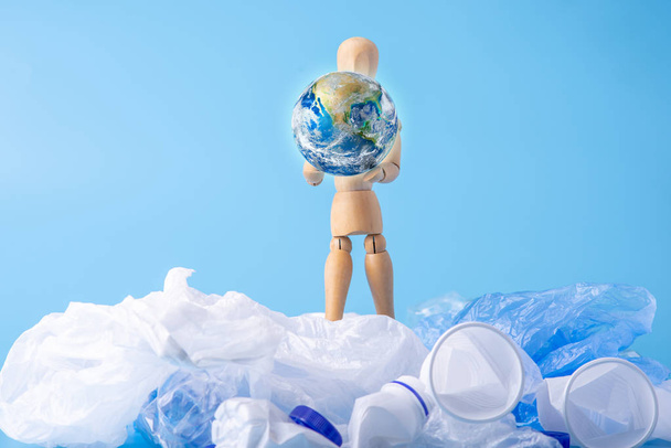Člověk ve formě dřevěných hraček nosí planetu v rukou, aby zachránil zemi před odpadky a plastem. Koncepce ekologie a recyklace odpadu. Prvky, které NASA poskytl - Fotografie, Obrázek