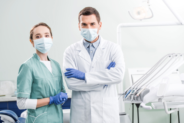 歯科医院で腕を組んだ突っ立っているマスクでは歯科医 - 写真・画像