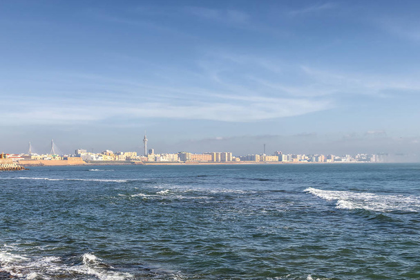 View of Cadiz cityscape from the ocean with mist entering in the bay. Fog above the waters. - Foto, imagen