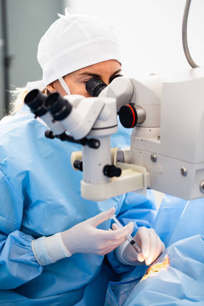 Lääkäri, joka käyttää mikroskooppia silmäleikkauksen aikana, kaihin ja diopterin korjauksen hoidossa. Terveydenhuollon ja teknologian teema
. - Valokuva, kuva