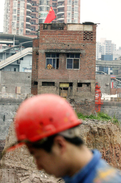 The Isolated House which stands alone in a 30 feet deep man-made pit at a real estate construction site before being demolished by local government in Chongqing city, 22 March 2007 - Fotó, kép