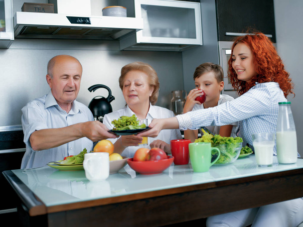 feliz familia sentada en la mesa con desayuno saludable
 - Foto, Imagen