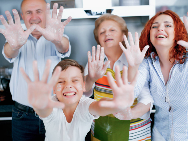 famille heureuse montrant les mains dans la farine à la cuisine
 - Photo, image