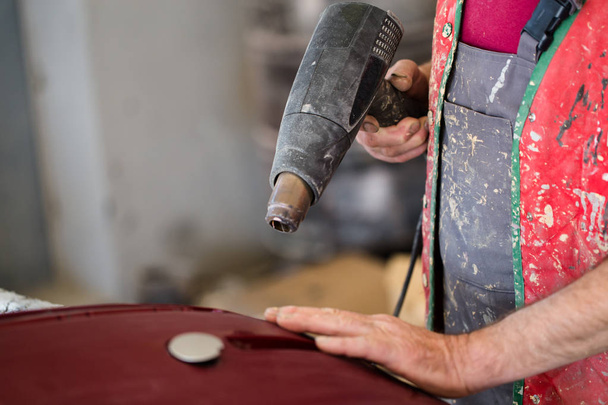 Car detailing - Man with sandpaper in auto repair shop sanding polishing and preparing car parts for painting - 写真・画像