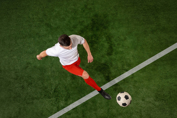 Football player tackling ball over green grass background - Fotoğraf, Görsel