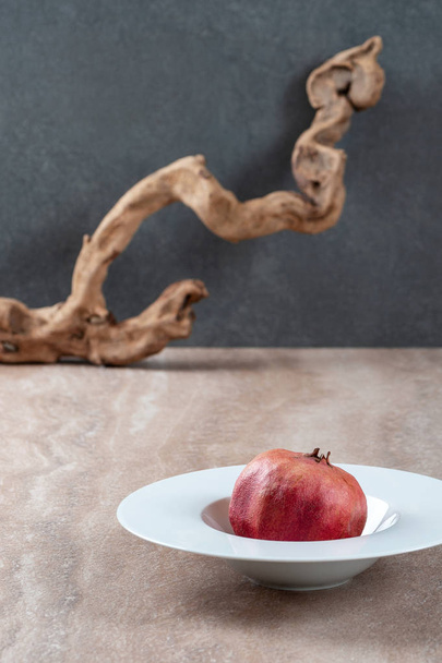 Conceptual food photography: pomegranate in a white plate. - Photo, image