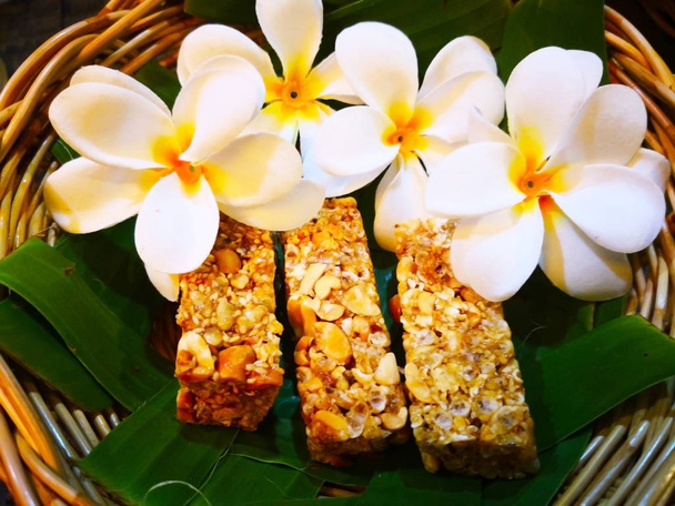 élelmiszer és desszert fogalom. Thai édességek banánlevél, fonott kosarak helyezkednek el. És fehér virágokkal díszített. Szelektív összpontosít és másol tér. - Fotó, kép