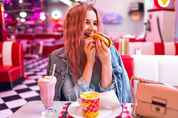 woman eating hotdog in  in cafe  - Фото, зображення