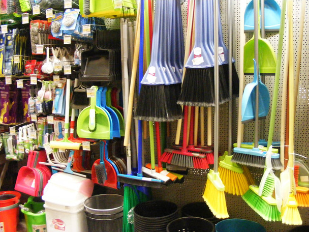 Разнообразие красочных метл и кистей, бытовое оборудование в магазине
 - Фото, изображение