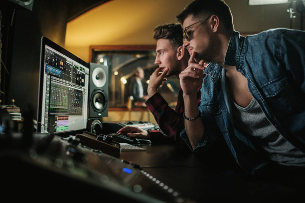Sound engineer working in a music studio - Foto, afbeelding