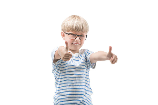 Little cute child isolated on white. Adorable funny boy holding thumb up. Kid in eyeglasses. Closeup portrait of attractive caucasian boy blond. - Photo, Image