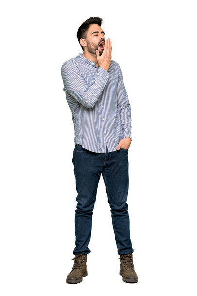 Tiro completo de homem elegante com camisa bocejando e cobrindo ampla boca aberta com a mão sobre fundo branco isolado
 - Foto, Imagem