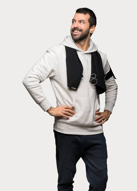 Sport man posing with arms at hip and laughing over isolated grey background - Foto, afbeelding