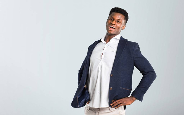 Handsome african american man wearing a jacket unhappy and suffering from backache for having made an effort on isolated grey background - Photo, Image