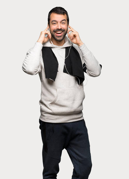 Sport man with headphones over isolated grey background - Foto, afbeelding