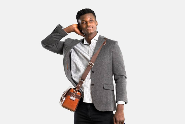 Africká americká obchodní muž cestující s kufry se smíchem na izolované šedé pozadí - Fotografie, Obrázek