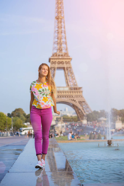 Happy girl walking in centre of Paris. Background of Eiffel tower. Travel concept - Фото, изображение
